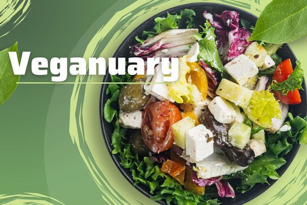 KI generiert: Das Bild zeigt eine bunte, frische Salatschüssel mit verschiedenen Gemüsesorten auf einem grünen Hintergrund. Auf der linken Seite befindet sich der Schriftzug "Veganuary".